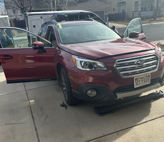 Subaru Outback prepared for a mobile windshield replacement in a driveway