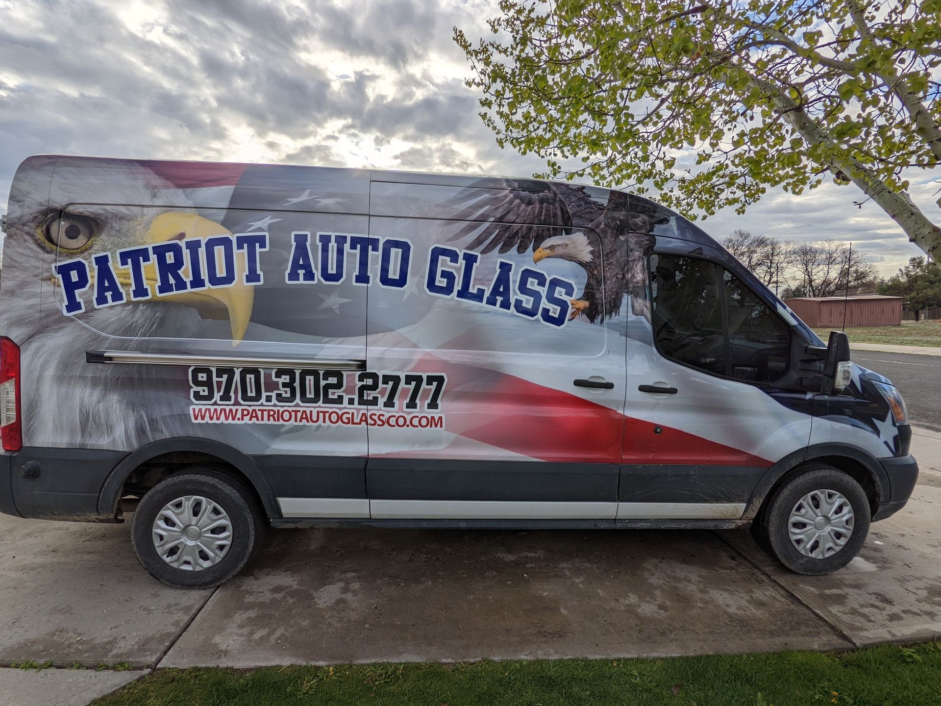 Patriot Auto Glass mobile service van with American flag and eagle wrap