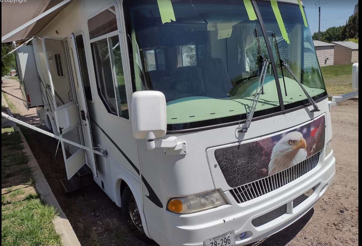 Motorhome windshield replacement in progress with fresh glass taped in place